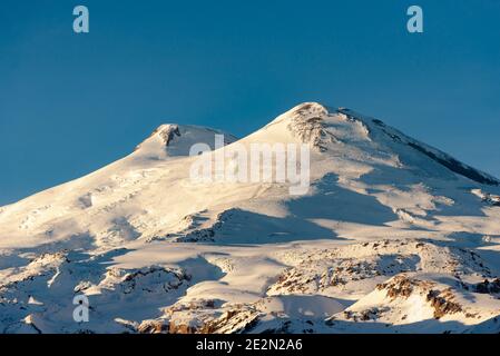 Mount Elbrus im Winter. Blick auf Elbrus vom nahe gelegenen Cheget Mountain. Hüte von Elbrus im Winter 2021 Stockfoto