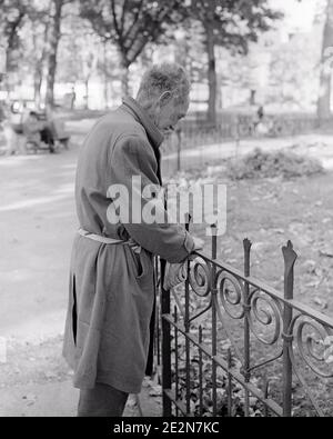 1960S 1970ER SENIOR MANN VAGRANT LEHNT SICH AN GELÄNDER IN DER STADT PARK ZERZAUSTE SCHMUTZIG SCHLECHT FITTING MANTEL MIT KRAWATTE GEBUNDEN - V239 HAR001 HARS MÄNNER NERVÖS SENIOR MAN SENIOR ADULT S&W ALKOHOLISCHE ANGST SUCHT ALTER OLDSTERS OLDSTER OBDACHLOS FITTING GELÄNDER VERZWEIFLUNG KRAWATTE ÄLTESTEN GEISTIGE GESUNDHEIT TRAMP KONZEPTUELLE VERKOMMEN BETÄUBUNGSMITTEL VORÜBERGEHEND BENACHTEILIGTE HOBO SPANNUNG WINO SÜCHTIGE ENTTÄUSCHT ENTTÄUSCHT GETRENNT GEWOHNHEIT VERARMT JUNKIE BENUTZER VAGABOND VAGRANT SCHWARZ UND WEISS KAUKASISCHEN ETHNIZITÄT ABHÄNGIGKEIT ZERZAUSTE VERSTÖRT UND AUS HAR001 GEISTESKRANKHEIT BEDÜRFTIGEN ALTEN ARBEITSLOS Stockfoto