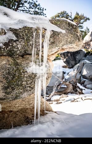 Eiszapfen bildeten sich im frühen Winter auf einem Felsen Stockfoto