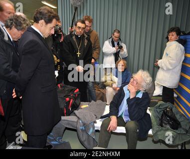 Der französische Präsident Nicolas Sarkozy (2. Dezember), flankiert von Innenminister Brice Hortefeux (L) und Umweltminister Jean-Louis Borloo (2. Dezember, teilweise versteckt), lauscht einem Opfer des Sturms von Xynthia, der am 1. März in einer Schule in L'Aiguillon-sur-Mer, Westfrankreich, untergebracht war. 2010 nach einem Flug über die überfluteten Gebiete zwischen La Rochelle und L'Aiguillon-sur-Mer. Xynthia hat diesen Teil der Atlantikküste am Vortag geschlagen, mindestens 50 Menschen getötet, riesige Wellen in exponierten Städten ins Landesinnere gefahren und Hunderte von Häusern überschwemmt. Bussereau ist Präsident des charente-Maritime County General council, in der Nähe von Vendee Stockfoto