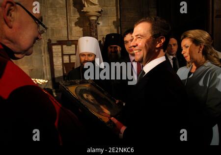 Der russische Präsident Dmitri Medwedew, Mitte rechts, seine Frau Svetlana, rechts, geben ein Gemälde an Mgr Patrick Jacquin, während sie die Kathedrale Notre Dame besuchen, in Paris, Frankreich am 2. März 2010. Russland und Frankreich haben am Montag in Paris ihre Wertung auf ein neues Niveau gebracht und Gespräche über den Verkauf von vier französischen Kriegsschiffen an Moskau aufgenommen, sich gemeinsam gegen den atomar gesinnten Iran gestellt und eine neue globale Finanzordnung gefordert. Foto von Christophe Ena/Pool/ABACAPRESS.COM Stockfoto