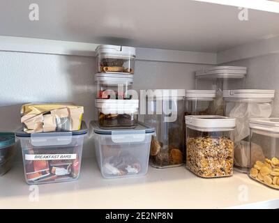 Eine organisierte Speisekammer Regal mit verschiedenen Arten von Cookies, Müsli und Snacks ordentlich in Kunststoffbehältern gelegt. Stockfoto