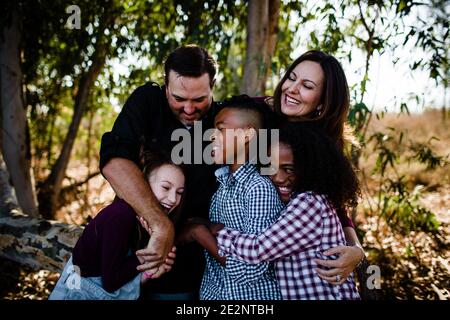 5-köpfige Familie umarmt und lacht im Park in Chula Vista Stockfoto