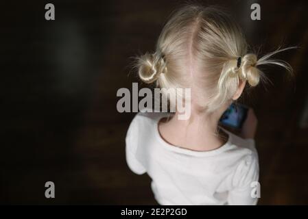 Portrait der blonden Haarbrötchen des kleinen Mädchens von hinten Stockfoto