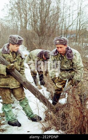 "Moldovische Grenzschutzbeamte entfernen den Stacheldraht zwischen Moldawien und Rumänien in Cotul Morii. 16. Februar 2010, Moldawien. Der moldauische Premierminister Vlad Filat hat einen Befehl unterzeichnet, um einen 60 Jahre alten Stacheldraht aus der kommunistischen Ära entlang des Flusses Prut zu entfernen, der sein Land von Rumänien trennt. Filat beschrieb den Zaun als eine Peinlichkeit und sagte: "Den Zaun entlang der Grenze mit einem befreundeten Land im 21. Jahrhundert zu erhalten, wenn Europas Grenzen völlig transparent sind und die Menschen sich frei bewegen, ist eine Schande." Foto von Dorin Goian/ABACAPRESS.COM' Stockfoto