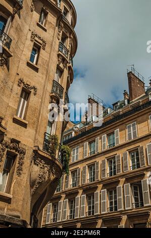 Fassade eines alten typischen Gebäudes mit Balkonen, Fenstern und sonnigem Tag in Paris. Eines der beeindruckendsten Kulturzentren der Welt. Frankreich. Stockfoto