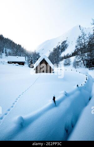Landschaftlich schöner Panoramablick auf idyllische Winterwunderland Berglandschaft in Die Alpen mit Schnee in alten traditionellen Berghütten Stockfoto