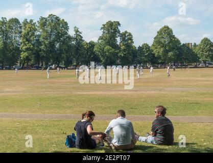 Menschen beobachten ein Cricket-Spiel auf Richmond Green, Richmond, Middlesex, England, Großbritannien Stockfoto