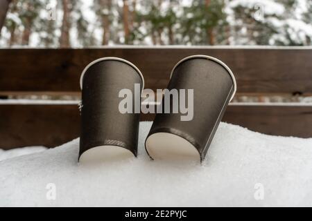 Zwei Pappbecher mit Kaffee auf einer Schneebank küssen sich gegenseitig, Winter Liebesgeschichte Stockfoto