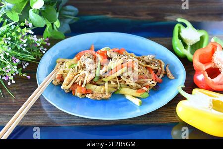 Udon mit Huhn und Gemüse in Sojasauce auf dem Tisch. Für asiatische Gerichte Stockfoto