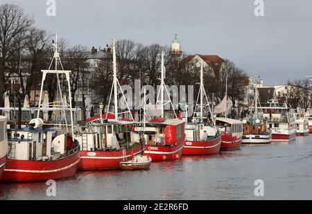 13. Januar 2021, Mecklenburg-Vorpommern, Warnemünde: Die roten Fischkutter, ehemalige Fischerboote, werden am Alten Strom des Ostseebades zusammen mit Fahrgastschiffen und Fischkuttern vertäut. Die Fischkutter - wie die Passagierschiffe - dürfen aufgrund der Corona-Vorschriften nicht mit Passagieren fahren. Die Corona staatliche Verordnung verbietet das Angebot von Angeltouren mit Kutter und kommerzielle Vermietung Boote. Foto: Bernd Wüstneck/dpa-Zentralbild/dpa Stockfoto