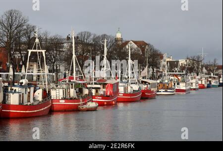 13. Januar 2021, Mecklenburg-Vorpommern, Warnemünde: Die roten Fischkutter, ehemalige Fischerboote, werden am Alten Strom des Ostseebades zusammen mit Fahrgastschiffen und Fischkuttern vertäut. Die Fischkutter - wie die Passagierschiffe - dürfen aufgrund der Corona-Vorschriften nicht mit Passagieren fahren. Die Corona staatliche Verordnung verbietet das Angebot von Angeltouren mit Kutter und kommerzielle Vermietung Boote. Foto: Bernd Wüstneck/dpa-Zentralbild/dpa Stockfoto