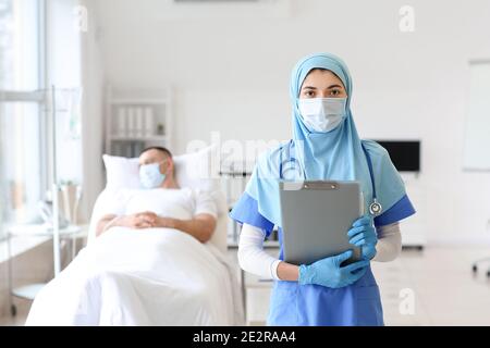Portrait einer muslimischen Ärztin mit Schutzmaske in der Klinik Stockfoto