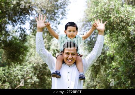 Mann Junge Huckepack Reiten im freien Lächeln Stockfoto