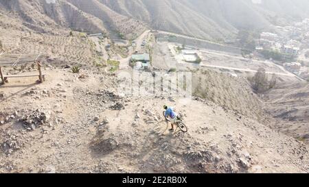 Mann, der mit dem Mountainbike auf dem kargen felsigen Gelände unterwegs ist Stockfoto