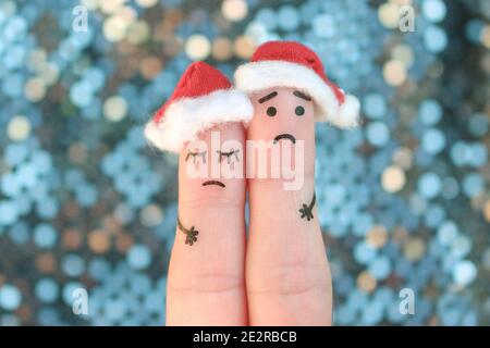 Finger Kunst der unzufrieden Paar feiert Weihnachten. Konzept der traurigen Mann und Frau in Neujahr Hüte. Stockfoto