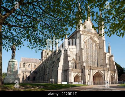 WINCHESTER, HAMPSHIRE, Großbritannien - 26. APRIL 2009: Außenansicht der Vorderfassade der Winchester Cathedral, eingerahmt von Frühlingslaub Stockfoto