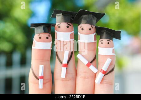 Finger Kunst von Studenten in medizinische Maske aus COVID-2019. Absolventen, die ihr Diplom nach dem Abschluss halten. Stockfoto