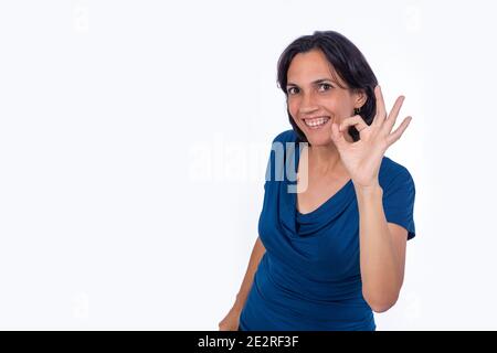 Lächelnde Frau macht ok Symbol mit ihrer Hand. Weißer Hintergrund Stockfoto