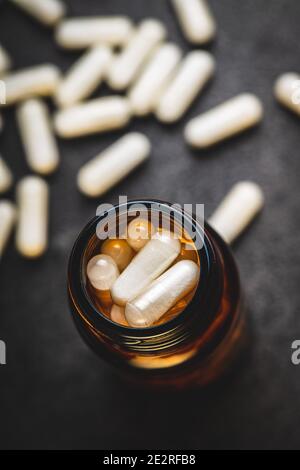 Weiße medizinische Pillen in Behälter. Pharmazeutische Medizin Pillen, Tabletten und Kapseln in Glas. Stockfoto