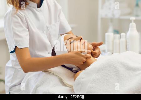 Therapeut macht professionelle manuelle entspannende Massage für junge Frau mit Finger Stockfoto