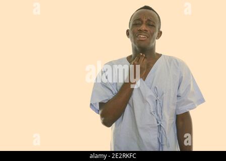 Studio shot von jungen schwarzen afrikanischen Mann Patient mit Halsschmerzen Stockfoto