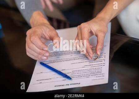 Mann und Frau, die ihre Eheringe ausziehen Stockfoto