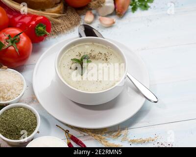 Yayla-Suppe (türkisch; 'Joghurtsuppe') mit buntem Gemüse auf dem weißen Tisch. Traditionelle türkische Küche Suppe. Stockfoto