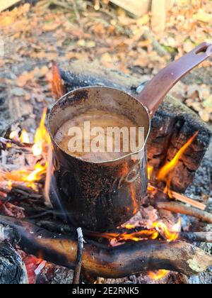 Kaffee wird in CEZVE auf Feuer zubereitet. Vertikales Bild. Stockfoto