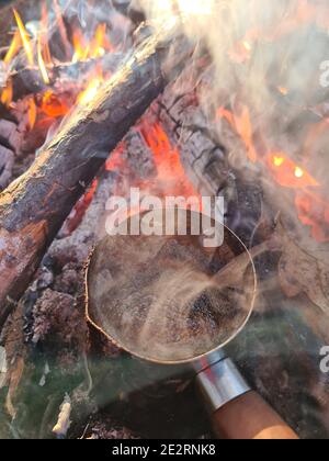 Kaffee wird in CEZVE auf Feuer zubereitet. Vertikale Zusammensetzung. Stockfoto