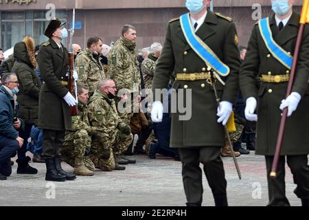 Non Exclusive: SAPORISCHSCHSCHJA, UKRAINE - 14. JANUAR 2021 - Soldaten knien während der Trauerfeier des umgekommen Soldaten OLEH Andriienko vor der Stockfoto