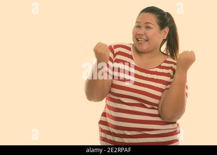 Studio shot der Jungen gerne Fett asiatische Frau lächelnd und Suchen begeistert Stockfoto