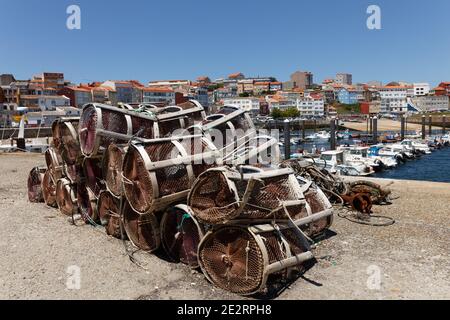 Krabben und Hummer Angeltöpfe gestapelt mit Blick auf die Stadt im Hintergrund, Finisterre, Galicien, Spanien Stockfoto