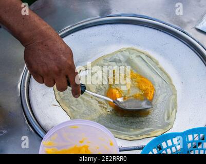 Zubereitung von leckeren Pfannkuchen mit einer Bananenfüllung bei einem Mobile Street Food Shop in Thailand Stockfoto