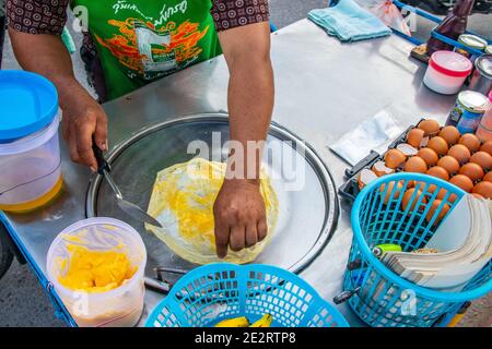 Zubereitung von leckeren Pfannkuchen mit einer Bananenfüllung bei einem Mobile Street Food Shop in Thailand Stockfoto