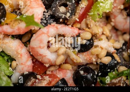 Gemüsesalat mit Garnelen und Pinienkernen auf einem Teller. Hausgemachtes Essen. Nahaufnahme Stockfoto