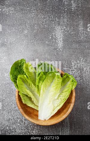 Frisch gewaschenen grünen Salat in Holzschüssel bereit zum Kochen. Zutaten zum Kochen, vegetarische Ernährung, gesunde Ernährung. Draufsicht, Platz für Text. Stockfoto