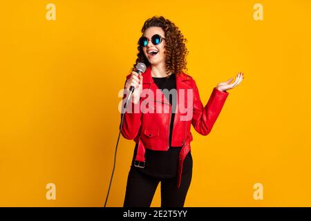 Portrait von ziemlich talentiert fröhlich wellig-haarige Mädchen Musiker singen Hit Isoliert auf hellgelbem Hintergrund Stockfoto