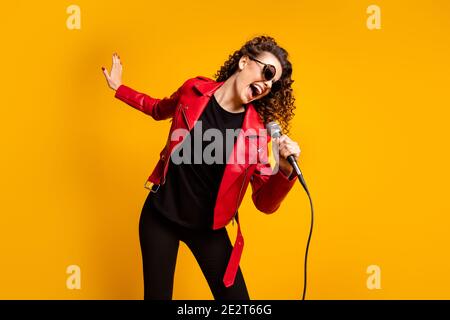 Portrait von attraktiven talentierten fröhlich wellig-haarigen Mädchen Stern genießen singen Romanze Song isoliert auf hellgelben Hintergrund Stockfoto