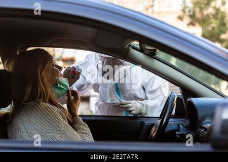 Medizinisches Personal Durchführen Drive-Thru COVID-19 Test, unter nasalen Tupfer Probe von weiblichen Patienten durch Auto-Fenster, PCR-Diagnose für Coronavirus, d Stockfoto