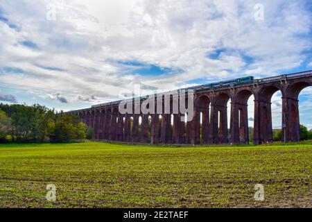 Trainieren Sie auf einer Eisenbahnbrücke auf dem Land in Großbritannien Stockfoto