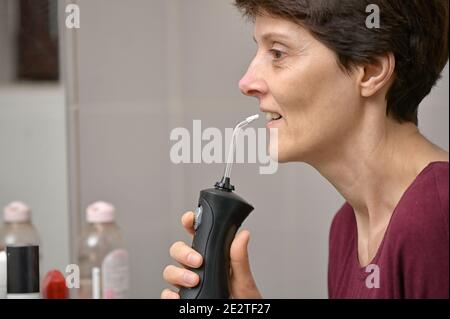 Porträt EINER jungen Frau und professionelle Oral Irrigator oder Flosser Stockfoto