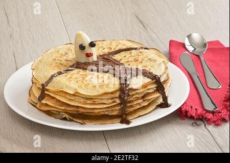 Stapel von gebackenen Pfannkuchen und Bananenfigur liegen auf Pfannkuchen Stockfoto