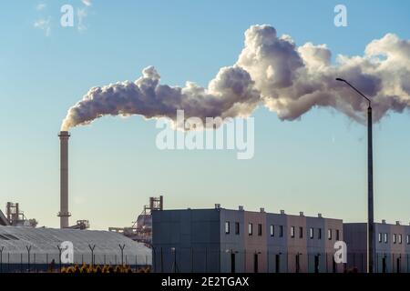 Rohre mit riesigen Rauchwolken in der Fabrik Nahaufnahme gegen den blauen Himmel an einem sonnigen Tag. Konzept der Ökologie, Umweltverschmutzung Stockfoto