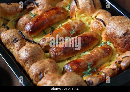 Traditionelle britische Küche, Würste und Zwiebeln in Teig gekocht bekannt als Kröte in the Hole Stockfoto