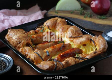 Traditionelle britische Küche, Würste und Zwiebeln in Teig gekocht bekannt als Kröte in the Hole Stockfoto