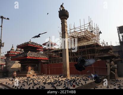 Kathmandu, Bagmati, Nepal. Januar 2021. Ein Junge spielt am 15. Januar 2021 auf dem Hanumandhoka Durbar Square in Kathmandu, Nepal, mit Tauben um die Wiederaufbaustelle eines beschädigten Tempels, der vom Erdbeben von 2015 betroffen war. Nepal war der 23. Tag der Erdbebensicherheit am Freitag, in Gedenken an die Verwüstung, die durch das Erdbeben in Nepal-Bihar 1934 verursacht wurde. Nepal sah sich am 2015. April einem weiteren Erdbeben ausgesetzt, das auch als Gorkha-Erdbeben bekannt ist, bei dem fast 9,000 Menschen ums Leben kamen und mehr als 22,000 verletzt wurden. Quelle: Sunil Sharma/ZUMA Wire/Alamy Live News Stockfoto