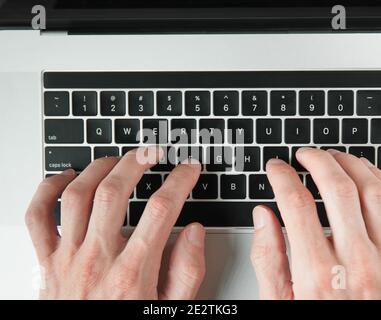 Draufsicht. Mann, der auf einer Laptop-Tastatur tippt. Stockfoto