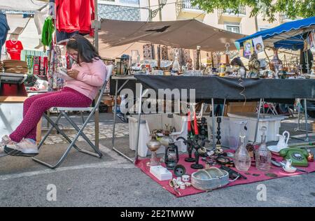 Junge Leserin, Bric-a-brac Stand am Mercado de Santa Clara (Feira da Ladra), Flohmarkt am Campo de Santa Clara Platz in Lissabon, Portugal Stockfoto