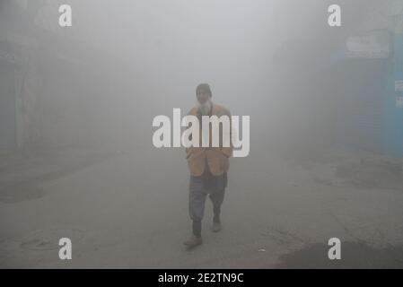 Lahore, Pakistan. Januar 2021. Pakistanische Pendler und Menschen machen sich an einem kalten Wintermorgen in Lahore inmitten dichten Nebels auf den Weg. Die Intensität des Nebels, die Sichtbarkeit wurde auf Null reduziert, so dass es schwierig für die Fahrzeuge zu manövrieren auf den Straßen. Die Verkehrspolizei hat Sicherheitsrichtlinien für Menschen erlassen, nachdem der Nebel in die Stadt gerollt wurde. Die Sicht muss auf weniger als 1 Kilometer reduziert werden, die Luftfeuchtigkeit muss mehr als 90 Prozent betragen, die Luft muss still sein und der Himmel muss klar sein. Nur dann gibt es Chancen für Nebel. (Foto: Rana Sajid Hussain/Pacific Press/Sipa USA) Quelle: SIPA USA/Alamy Stockfoto
